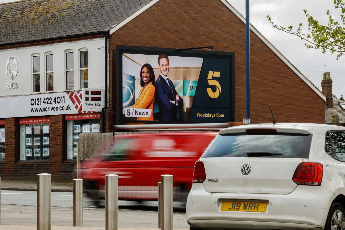 Large digital screen showing ad for Channel 5 news on the side of a building