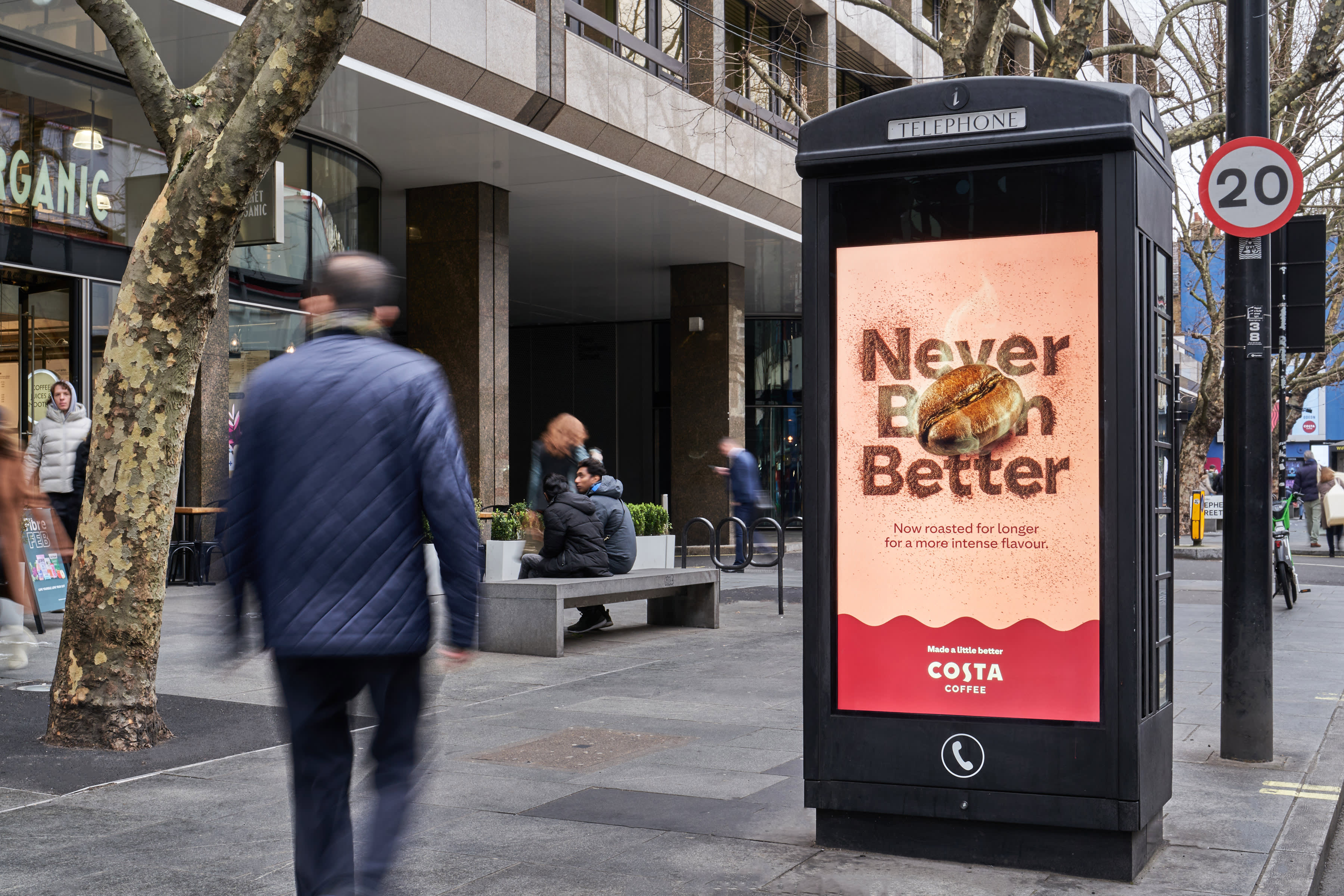 Phone box digital screen on a bust high street showing ad for Costa Coffee