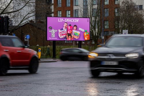 Digital billboard with passing cars in the evening