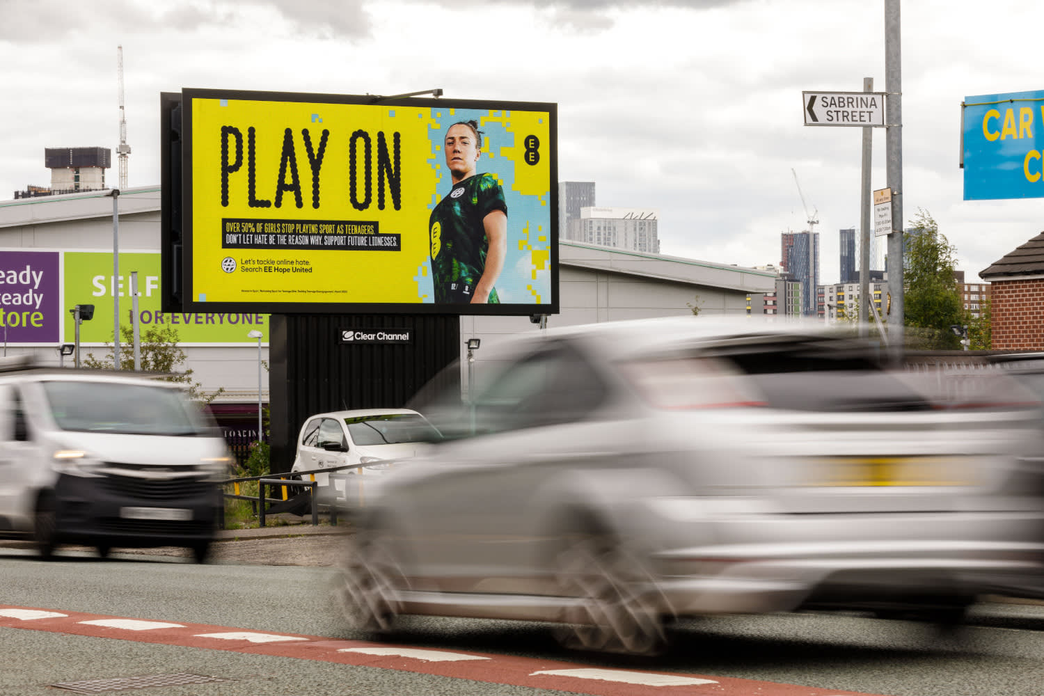 A yellow EE advert displaying on Clear Channel's Billboard Live screen in Manchester