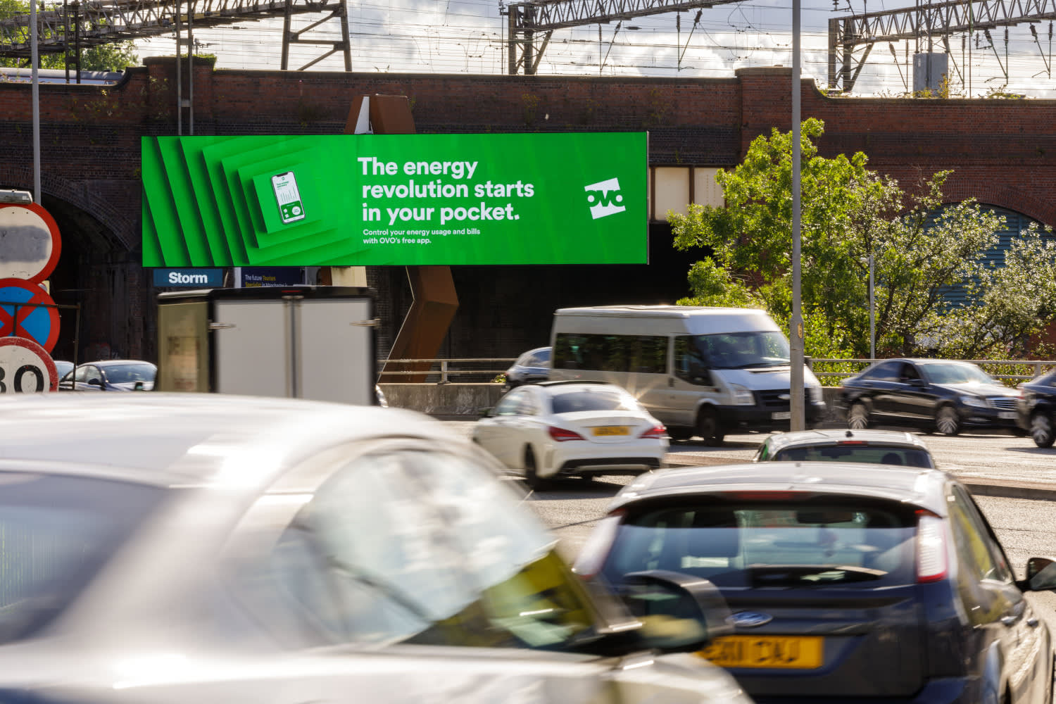 A large digital screen displaying an OVO campaign in Manchester