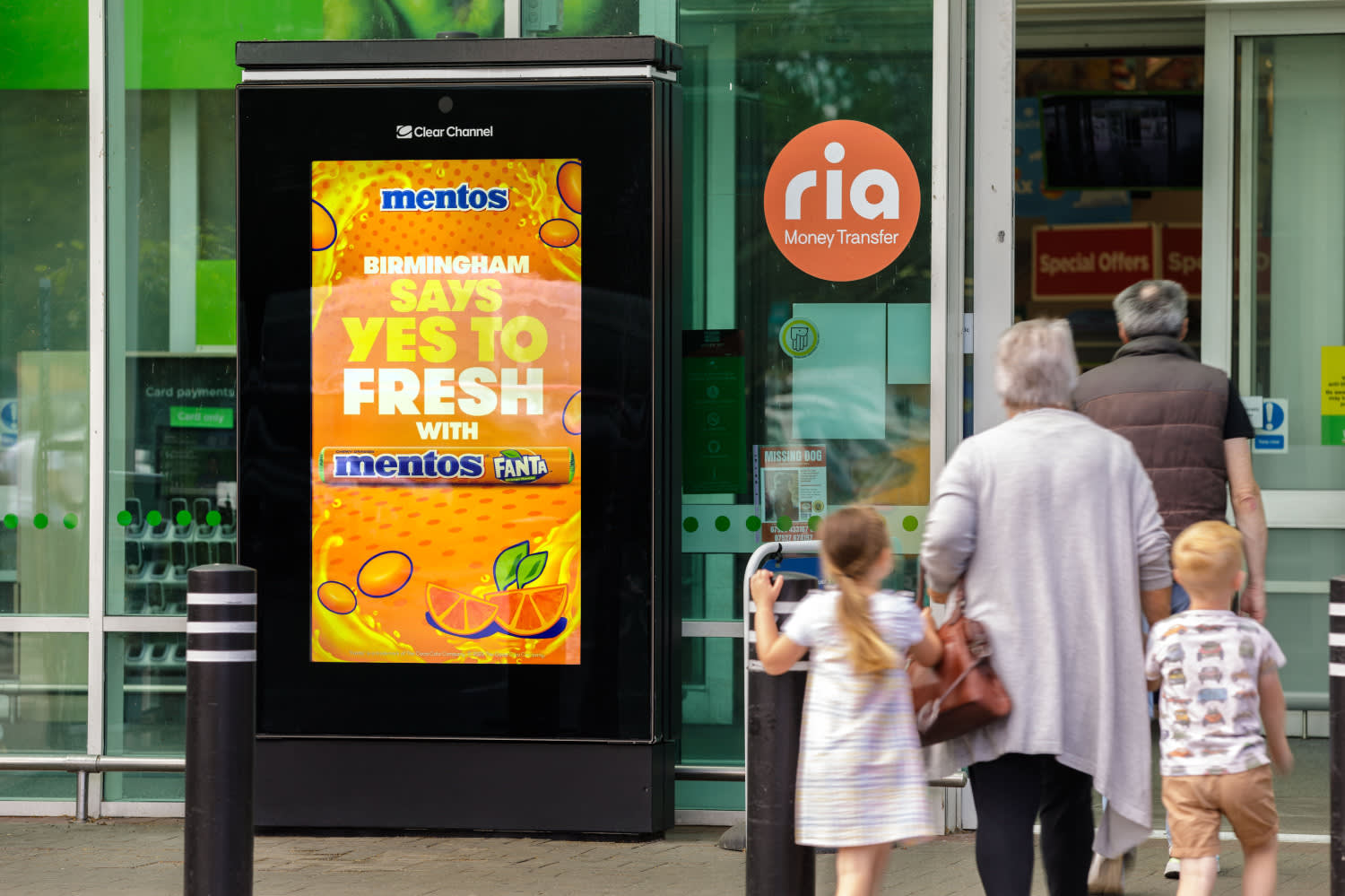 A colourful orange Asda Live digital campaign with families walking into the supermarket