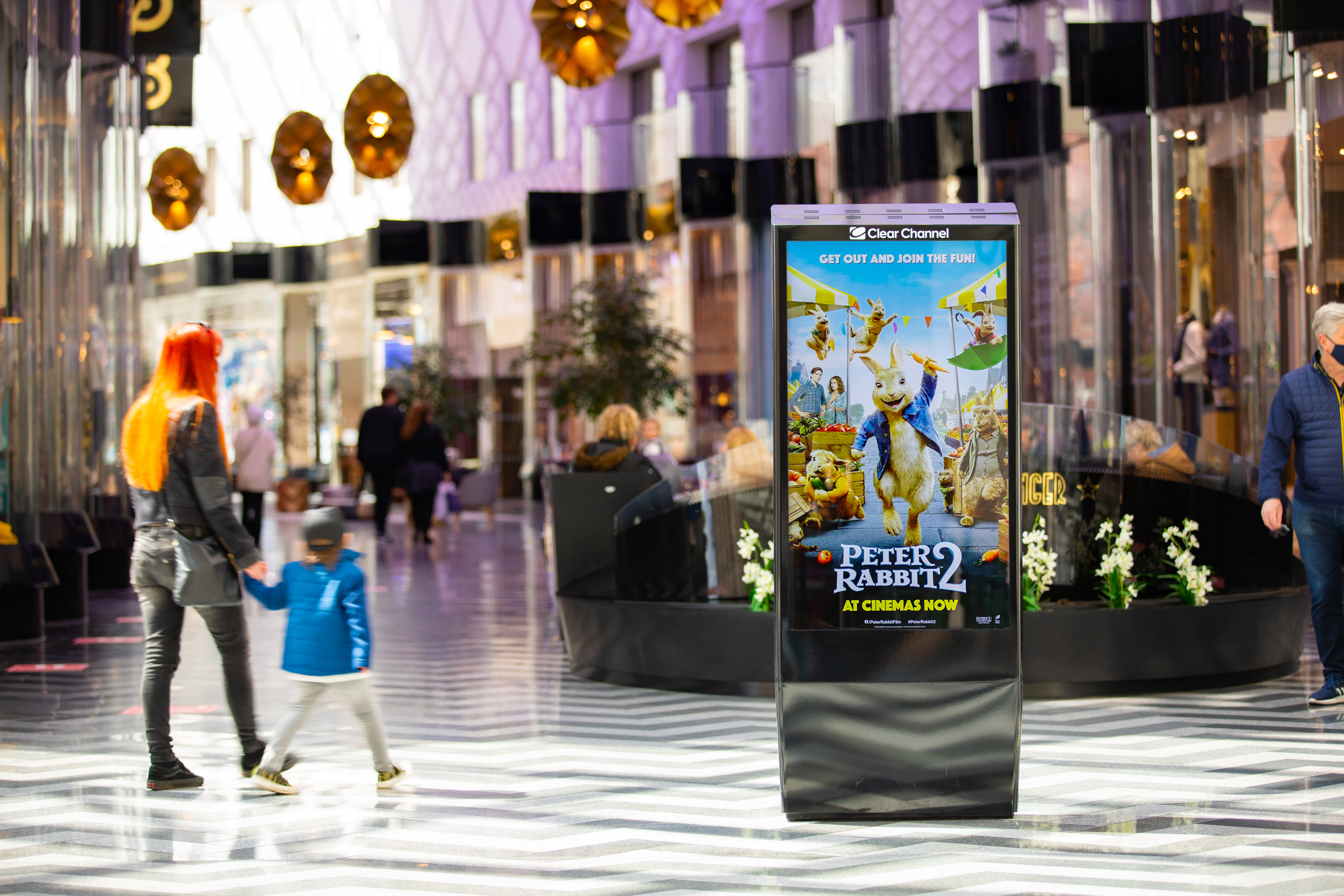 Digital screen in shopping mall showing ad for Peter Rabbit 2