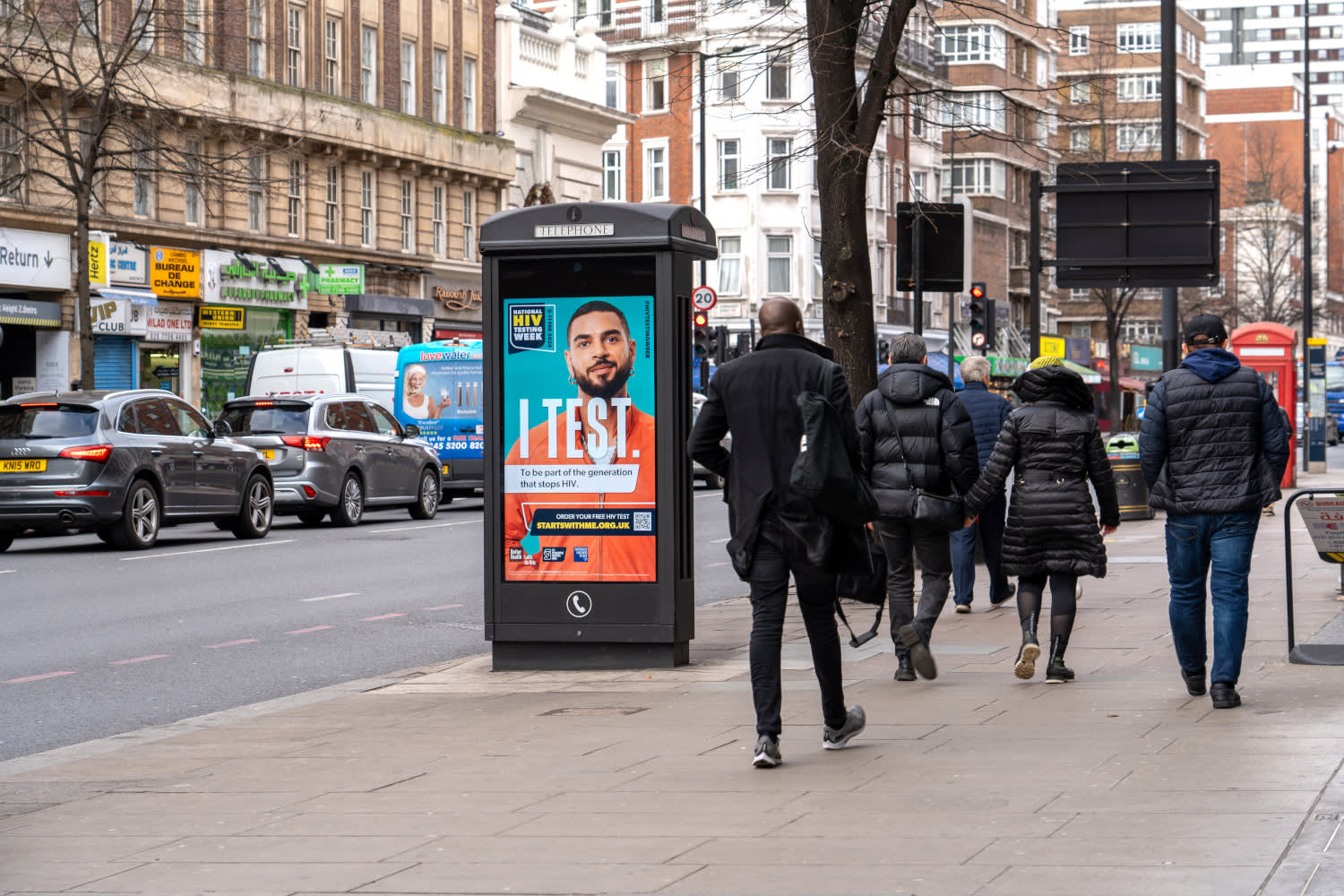 An 'I Test' campaign displaying on an Adshel Live screen on a busy high street