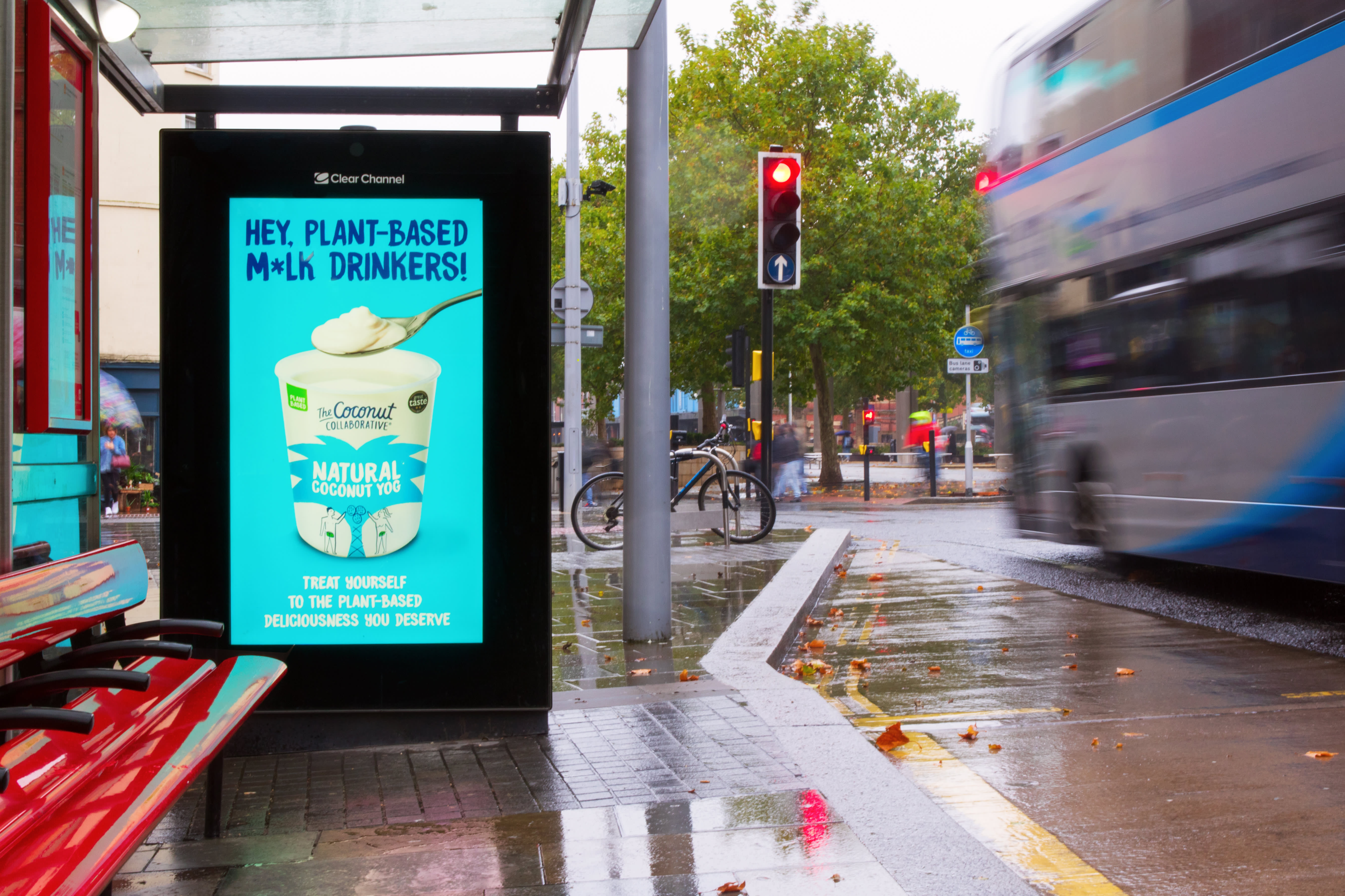 Digital screen on a bus stop showing ad for Coconut natural yogurt