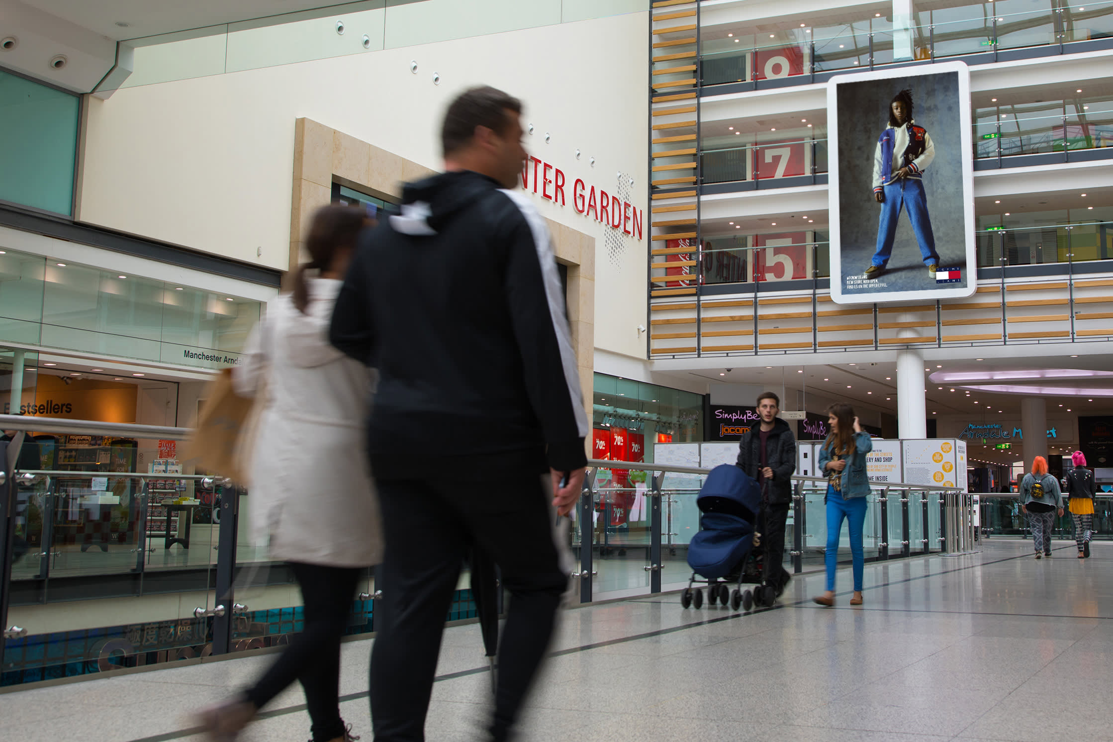 Large digital screen in shopping mall showing Tommy Hilfiger ad