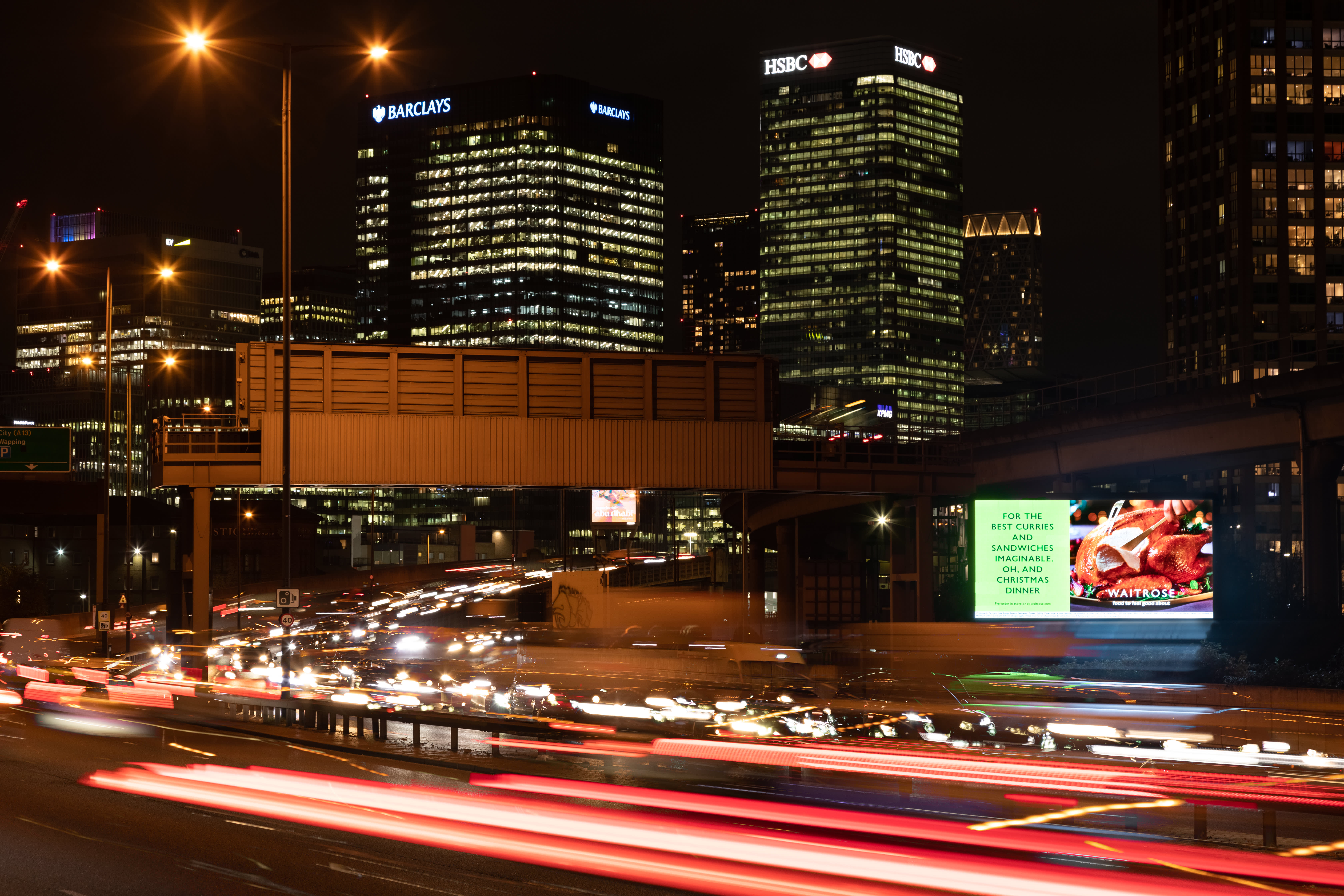 Billboard Live site on a busy main road at night showing Waitrose ad