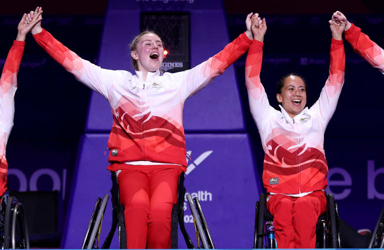 ** Neil Fachie and pilot Aaron Pope celebrate on velodrome podium with gold medals