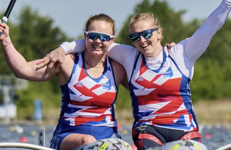 ** British Paralympic athletes celebrating with gold medals at international sporting competition podium