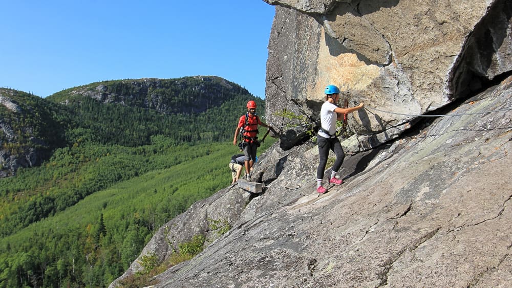 Clients sur la paroi de la via ferrata au Parc national des Grands-Jardins