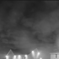 Nighttime clouds over the neighborhood houses with the very, *very* vague shape of a face in them.