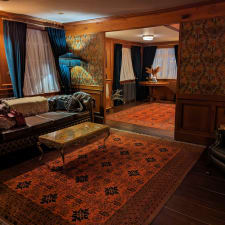 Old-fashioned hotel room with 1920s vibe. Sitting room with leather sofa and rug.