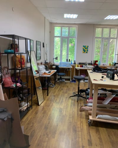 Maria’s atelier: workbenches, shelves of bags and rolls of leather