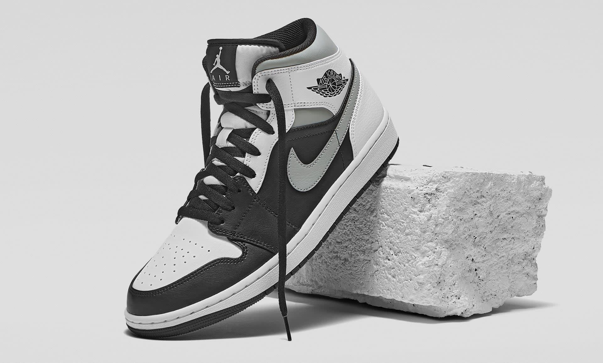 Glossy photo of Air Jordan 1 sneakers leant against a breeze block