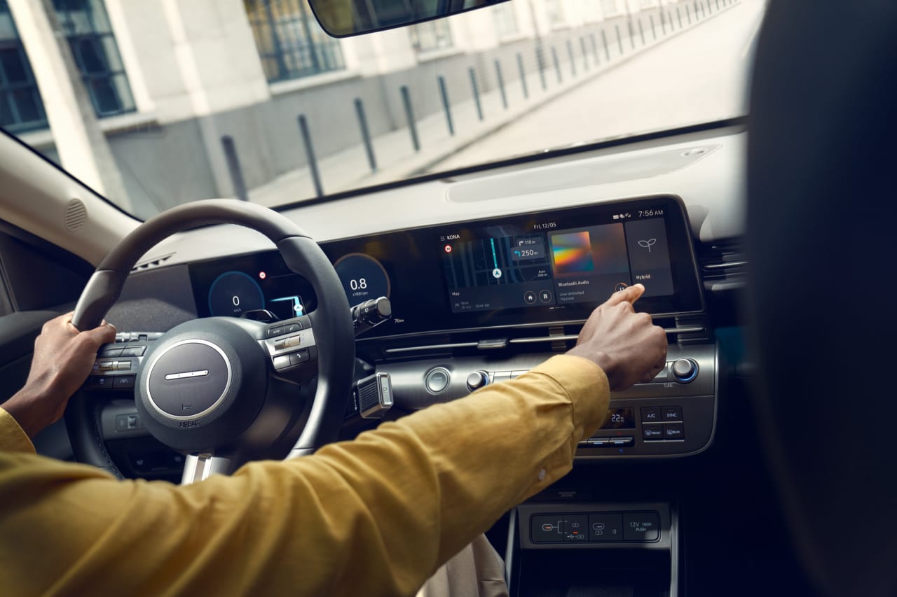 Doble pantalla digital del Hyundai KONA con el conductor tocando la pantalla