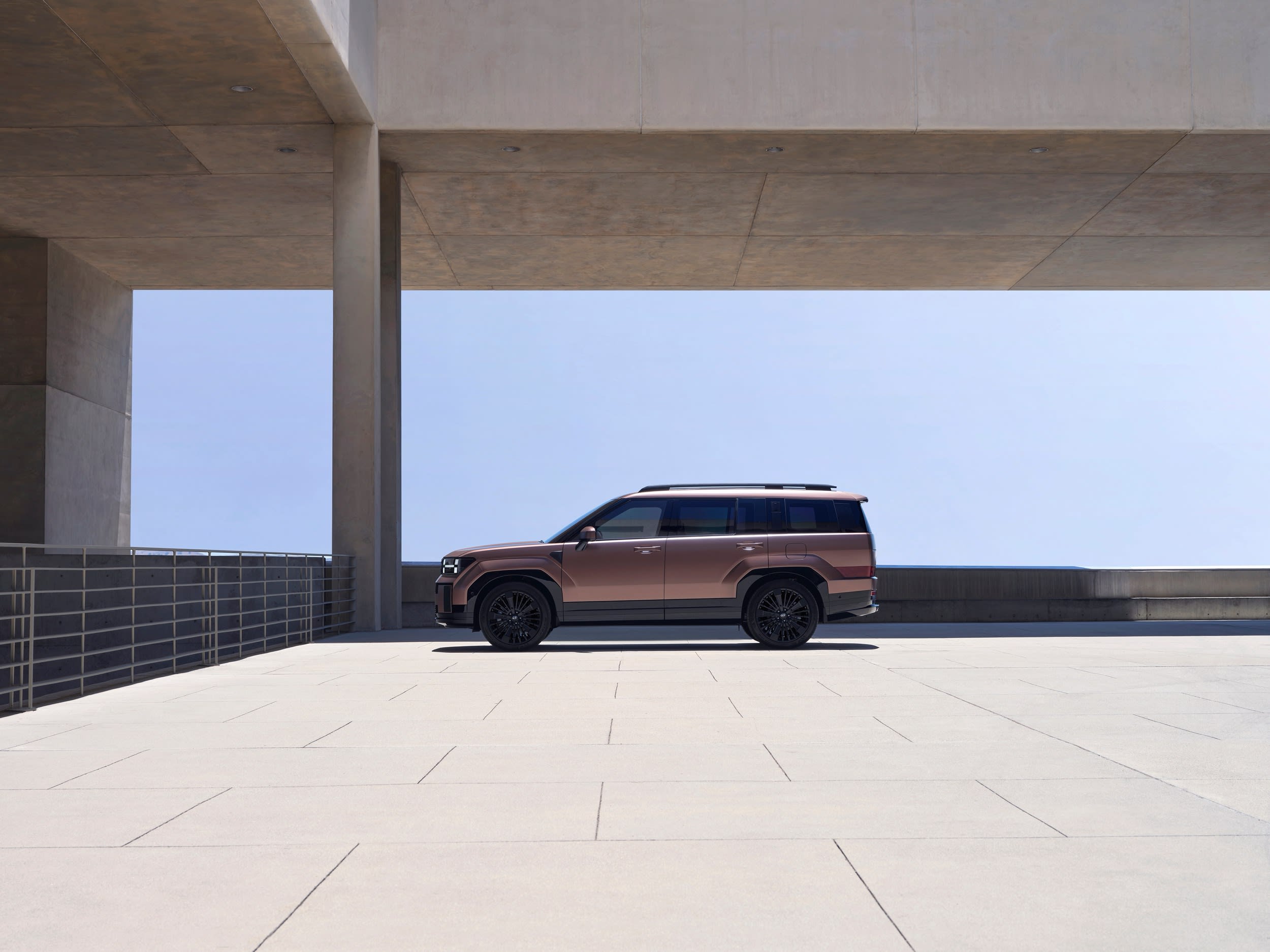 Hyundai SANTA FE aparcado bajo una estructura de hormigón, vista lateral