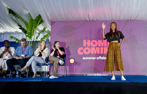 Stacks (Paystack employees) smiling and clapping as a fellow Stack models during the 2023 Homecoming Fashion Show.