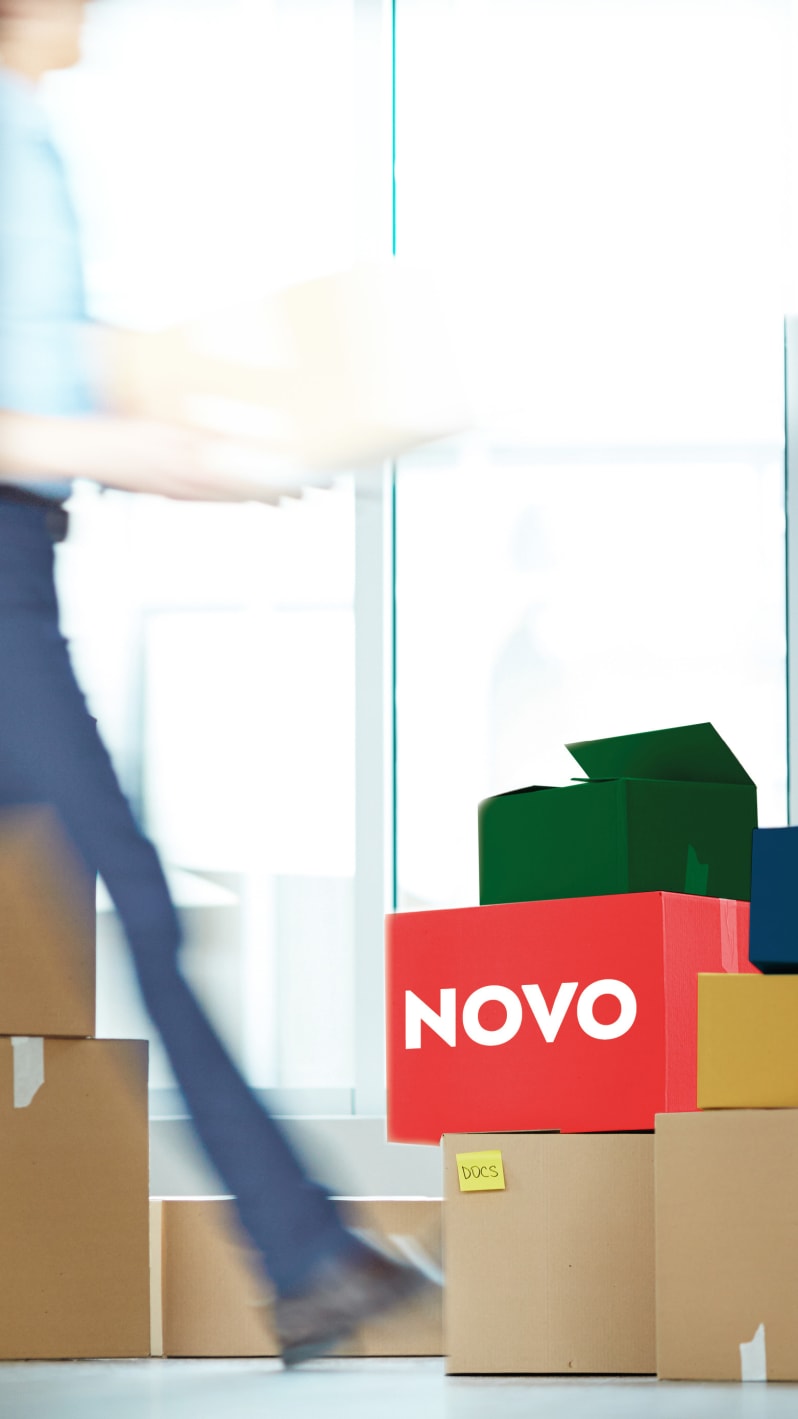 Colorful boxes stacked on top of each other, approached by a man with a box in his hand.
