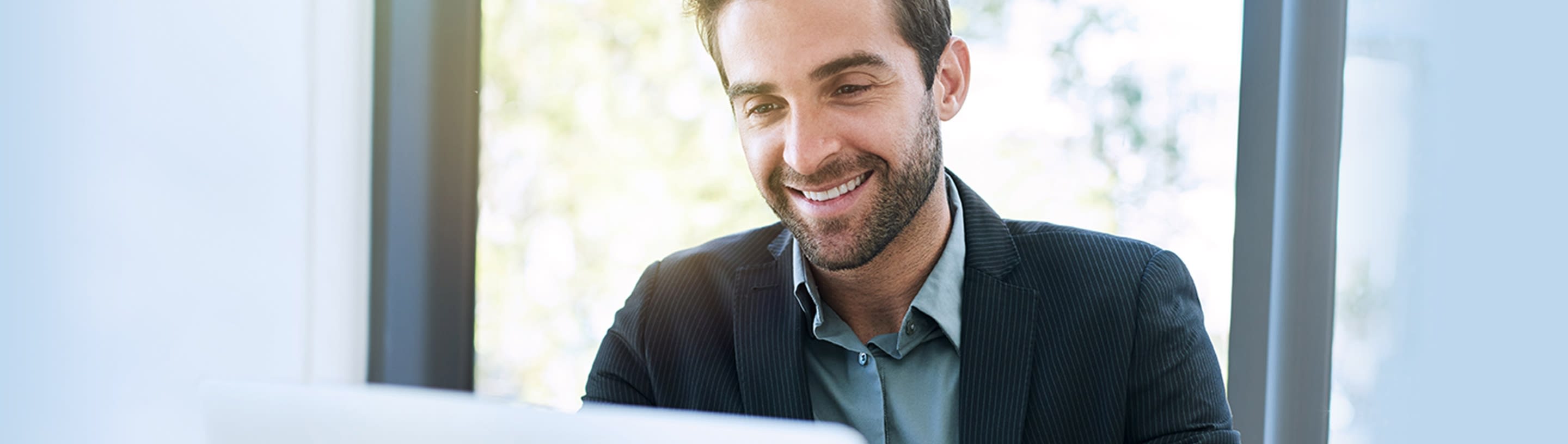 A smiling young man sits at a table.