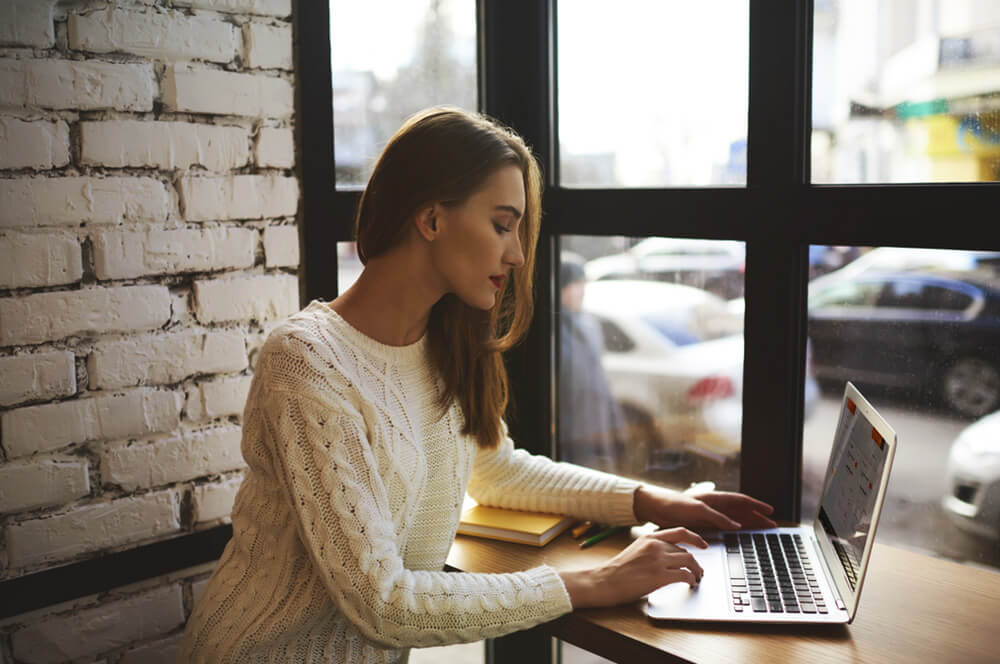 A young woman sits at a laptop.