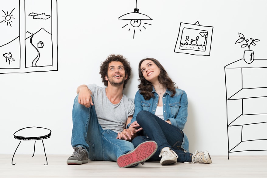 A young couple sits on the floor of a drawn room.