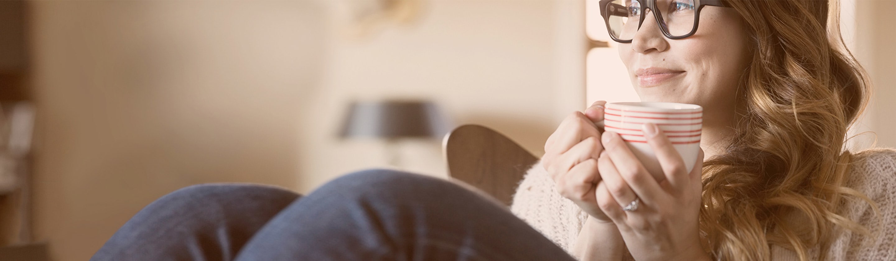 A young girl with a cup of coffee in her hand is resting relaxed.