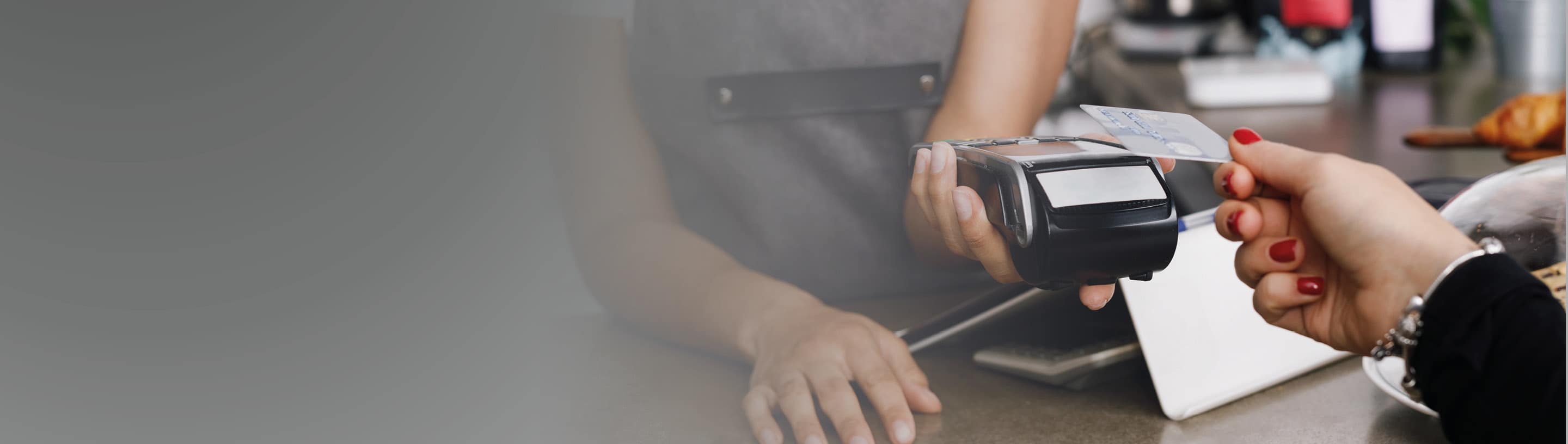 Payment card in hand leaning against POS device.