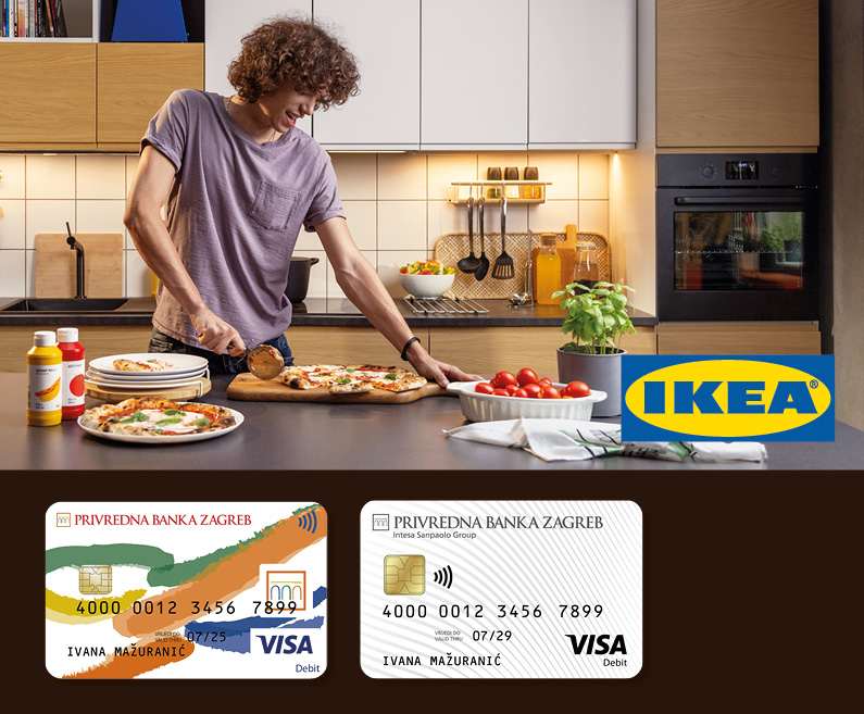 A young man in  Ikea kitchen cuts a pizza. Ikea logo and the old and new Visa Inspire card design.
