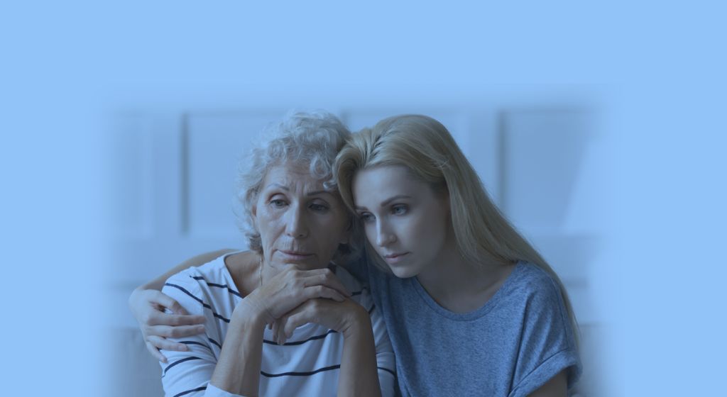 elderly woman and adult woman embracing
