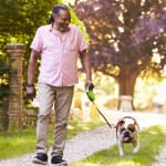 Black man walking a dog