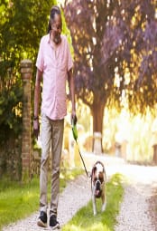 Black man walking a dog