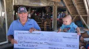 Man and baby holding a check.