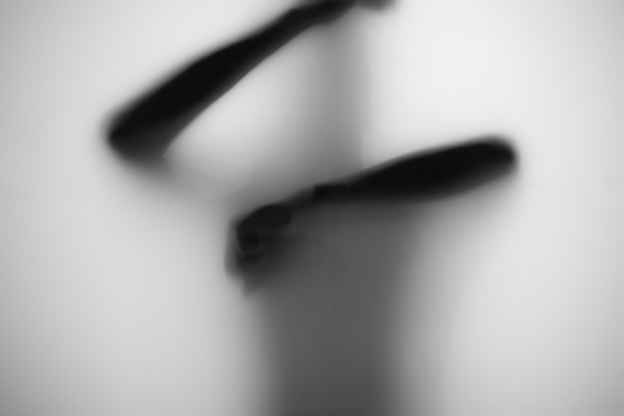 Bent limbs forming an abstract dark shape behind the glass
