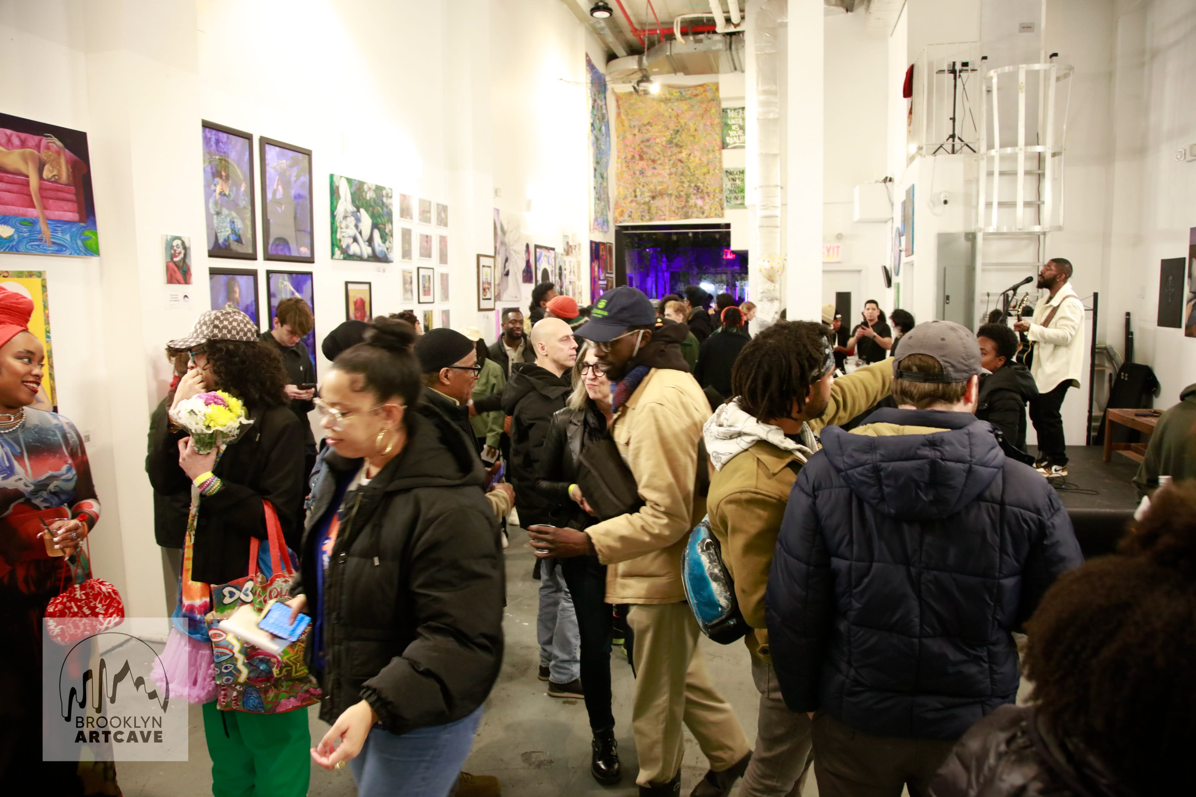 A group of four people engages in conversation during a pop-up event, with one person holding a cup and discussing while the others listen.