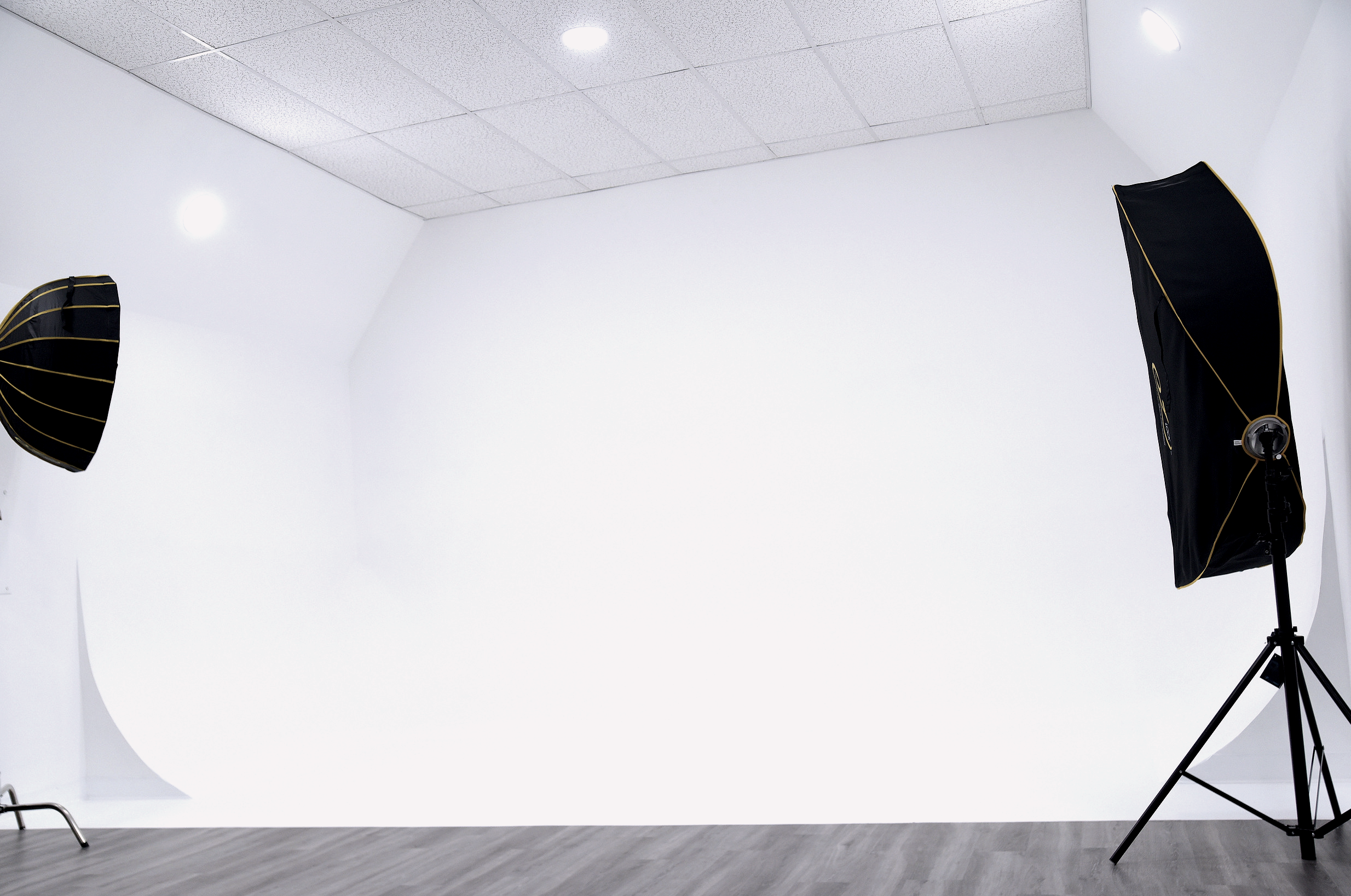 A filmmaker captures a man in a suit speaking during a video shoot, with multiple cameras and lights set up around the studio.
