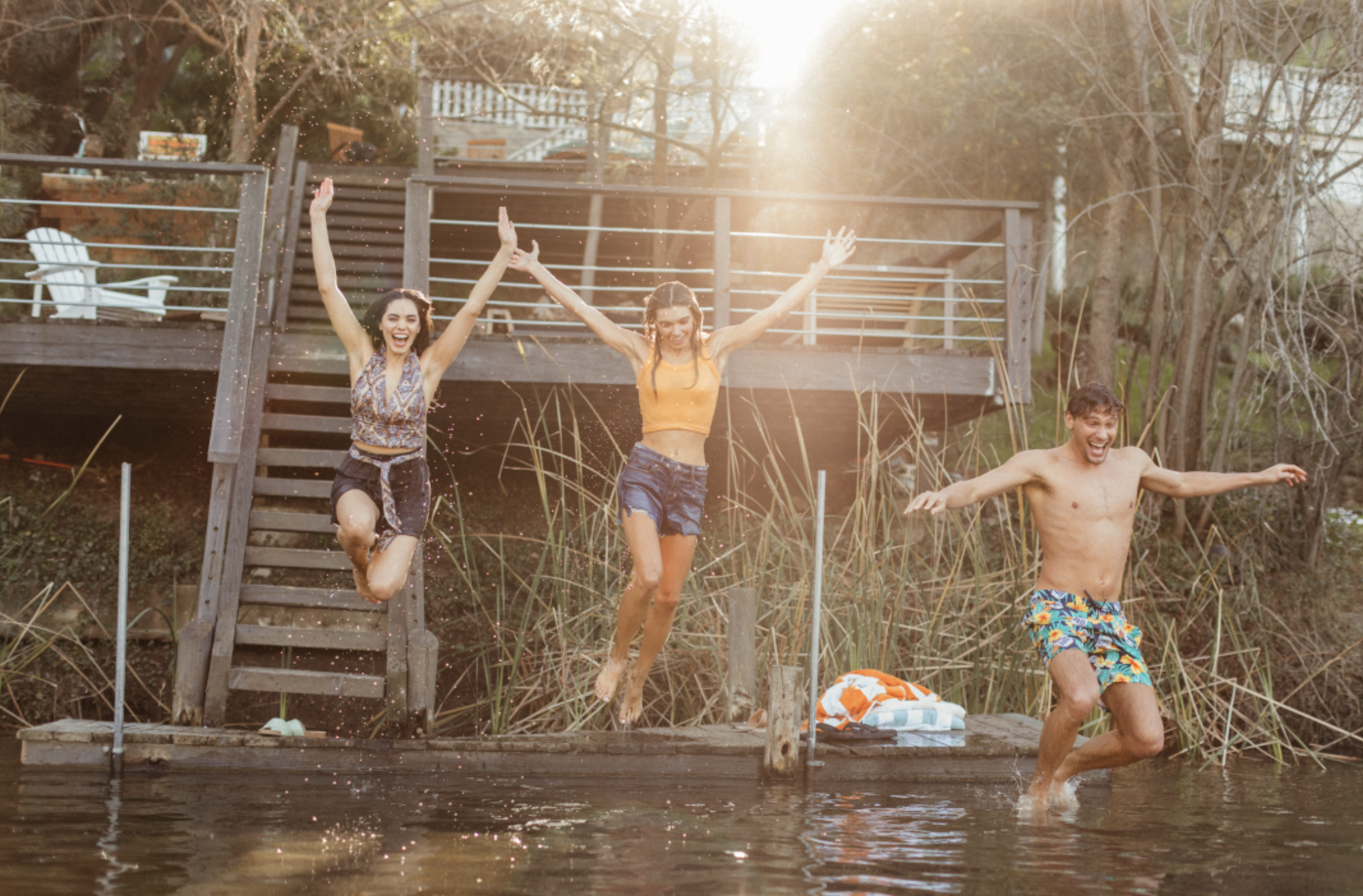 A family poses near a quiet lake while a photographer captures their photo as ducks swim by.