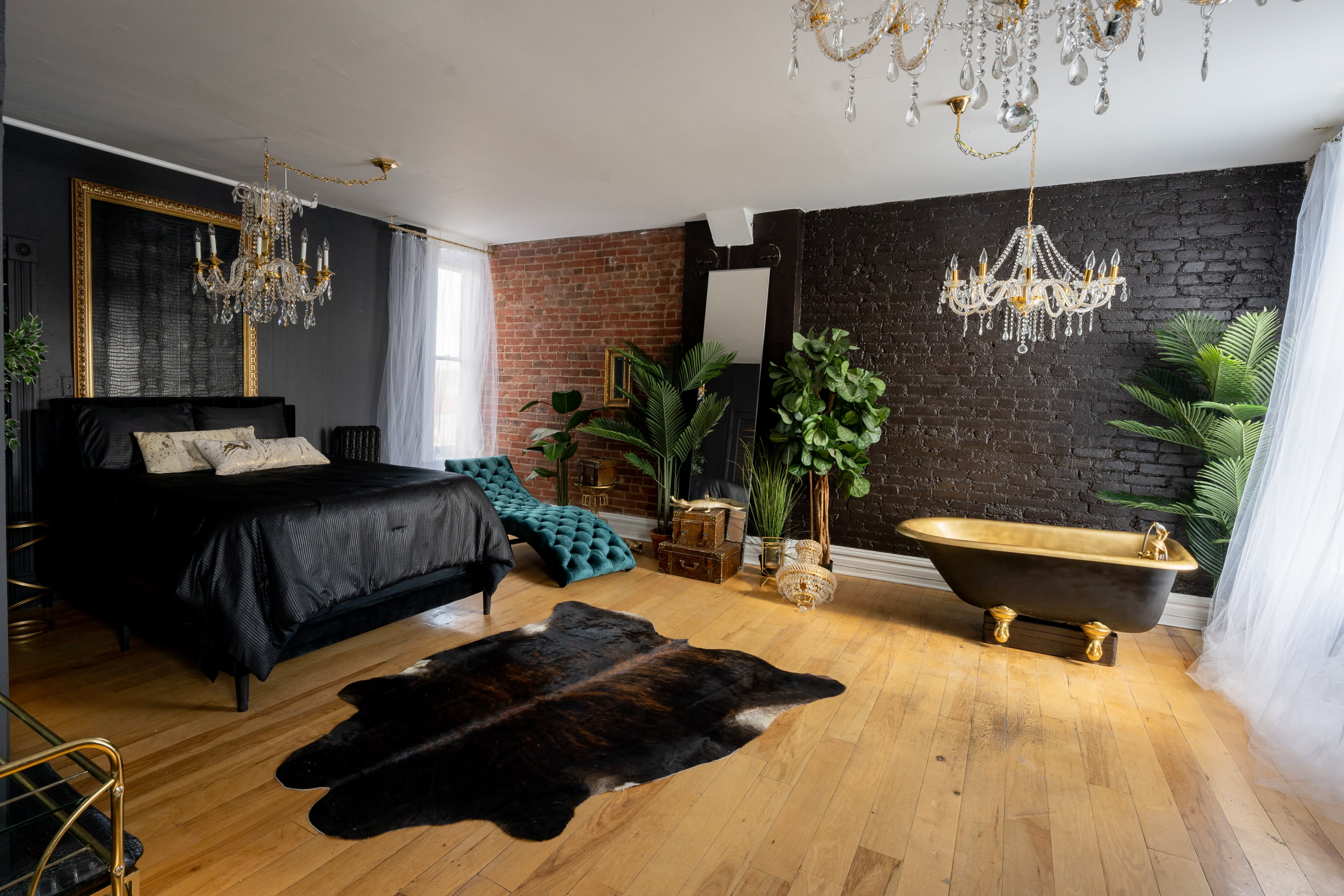 A couple poses intimately in a dimly lit room adorned with a sparkling chandelier.