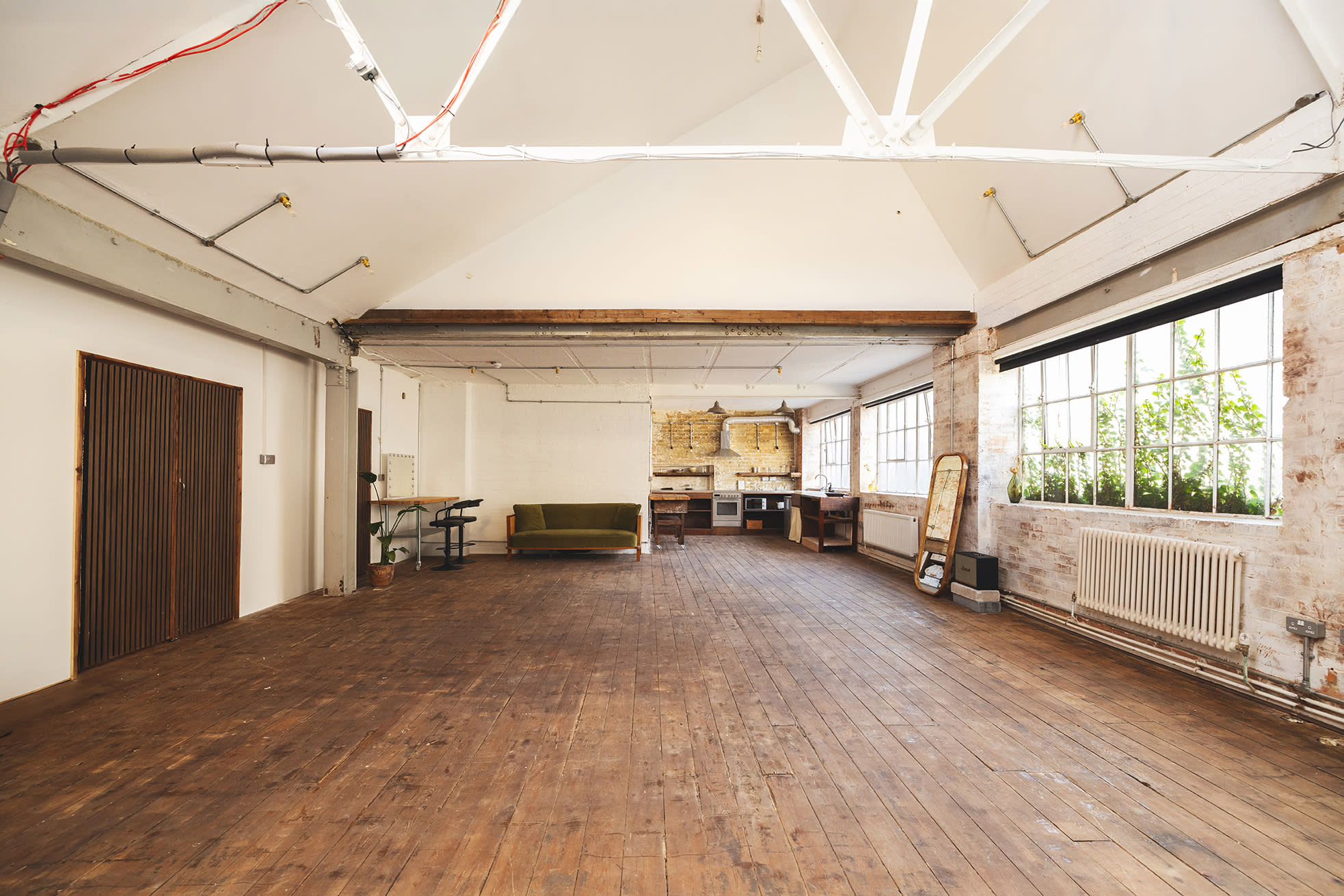 A photography studio is set up with a large umbrella light, a backdrop, a table, and various equipment for a photoshoot.