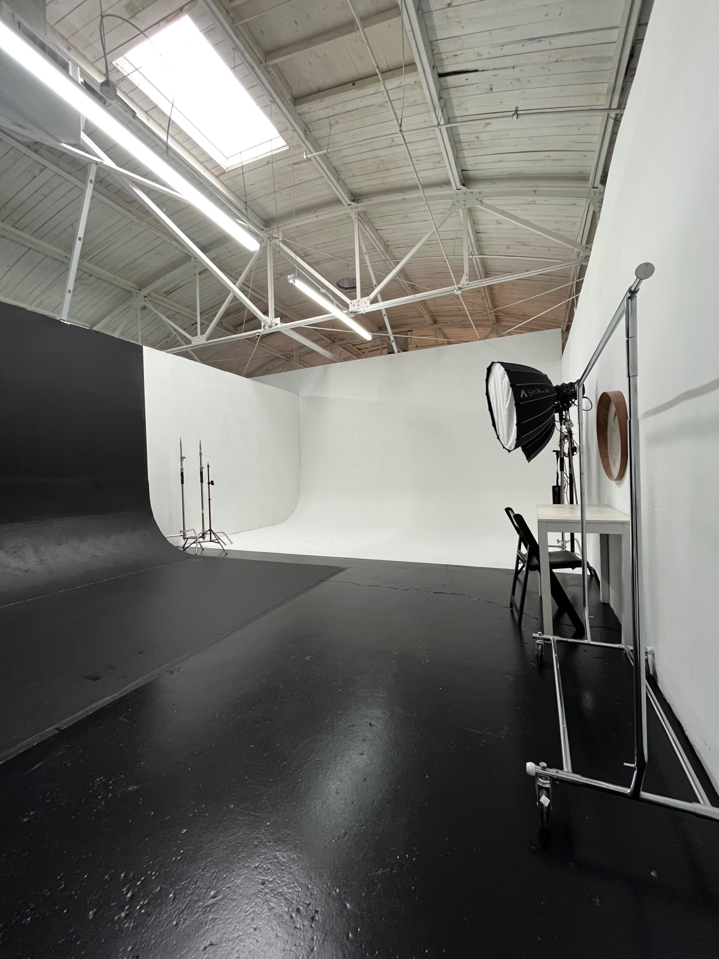 The photo shoot area features a large, empty space with black and white backdrops and a white pedestal in the center.