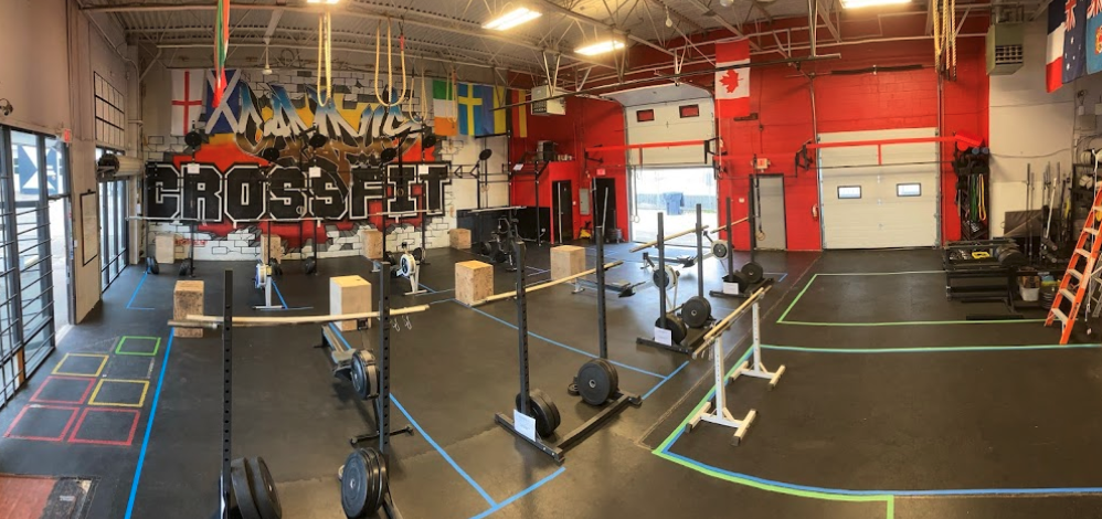 A shirtless man focuses intensely while preparing for a workout during a photo shoot.