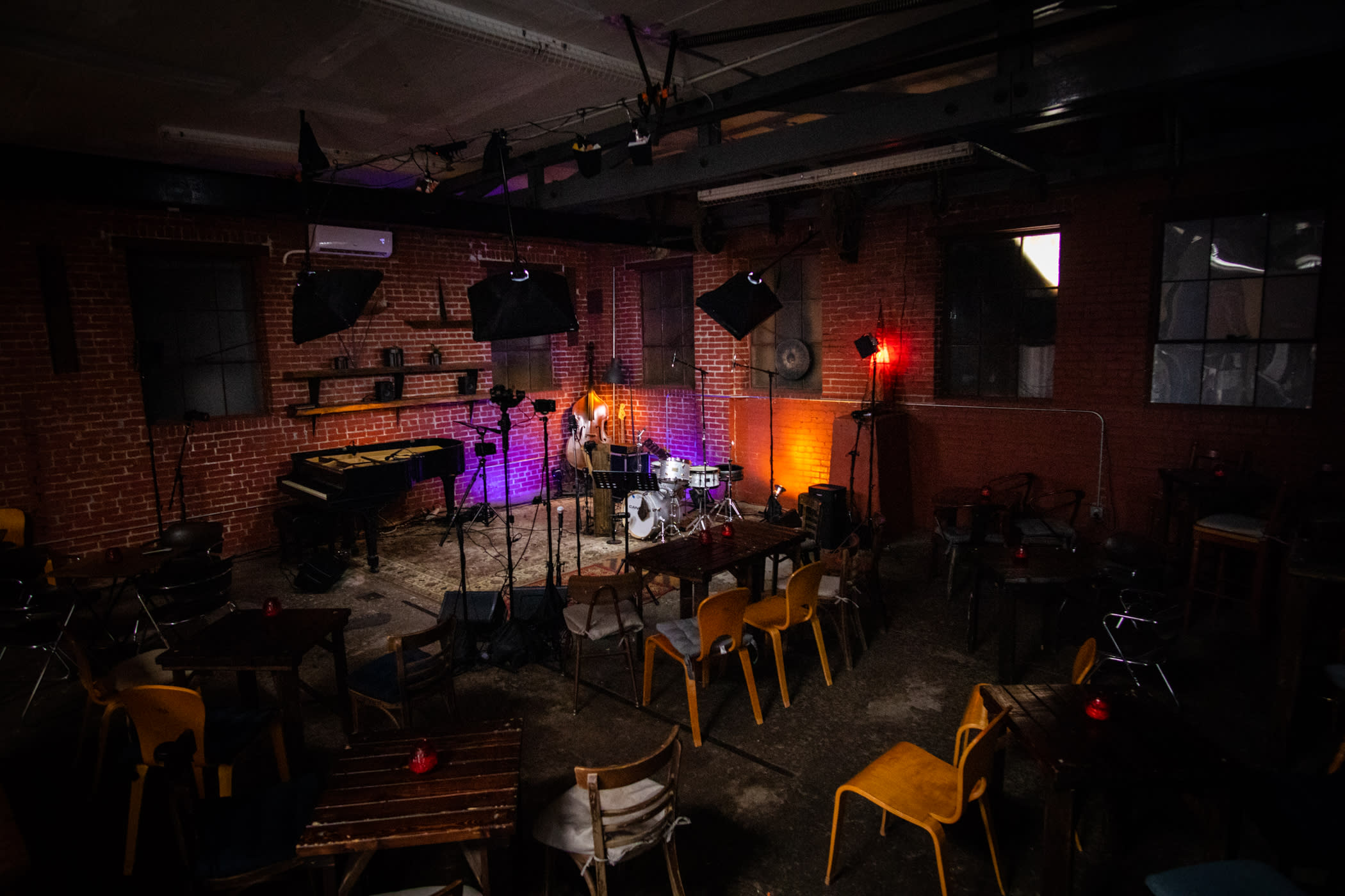 A video shoot is underway in a studio, with multiple cameras and lights set up around a presenter at a table.