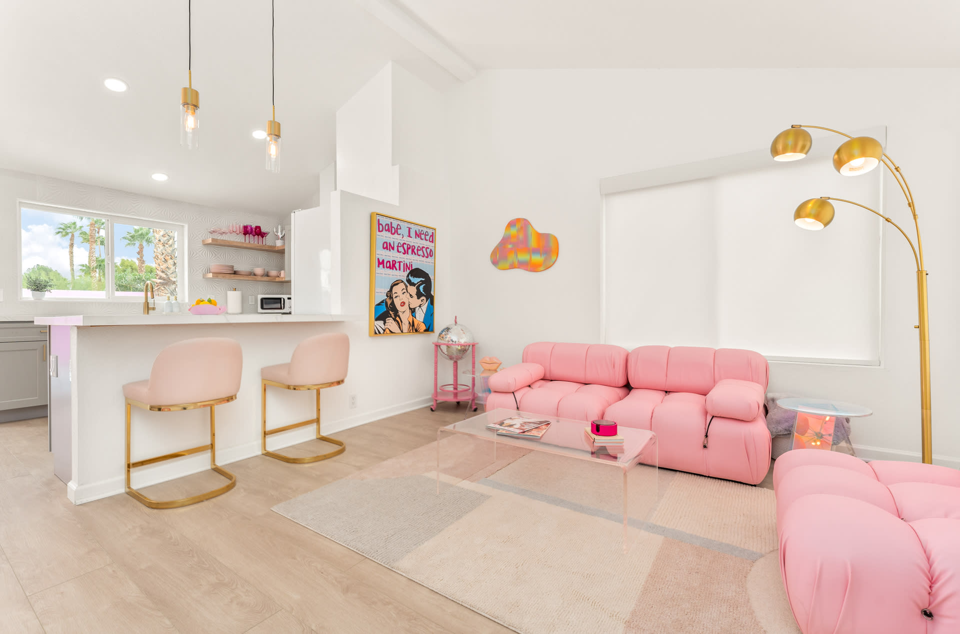 A model poses on a pink couch while holding a vintage telephone.
