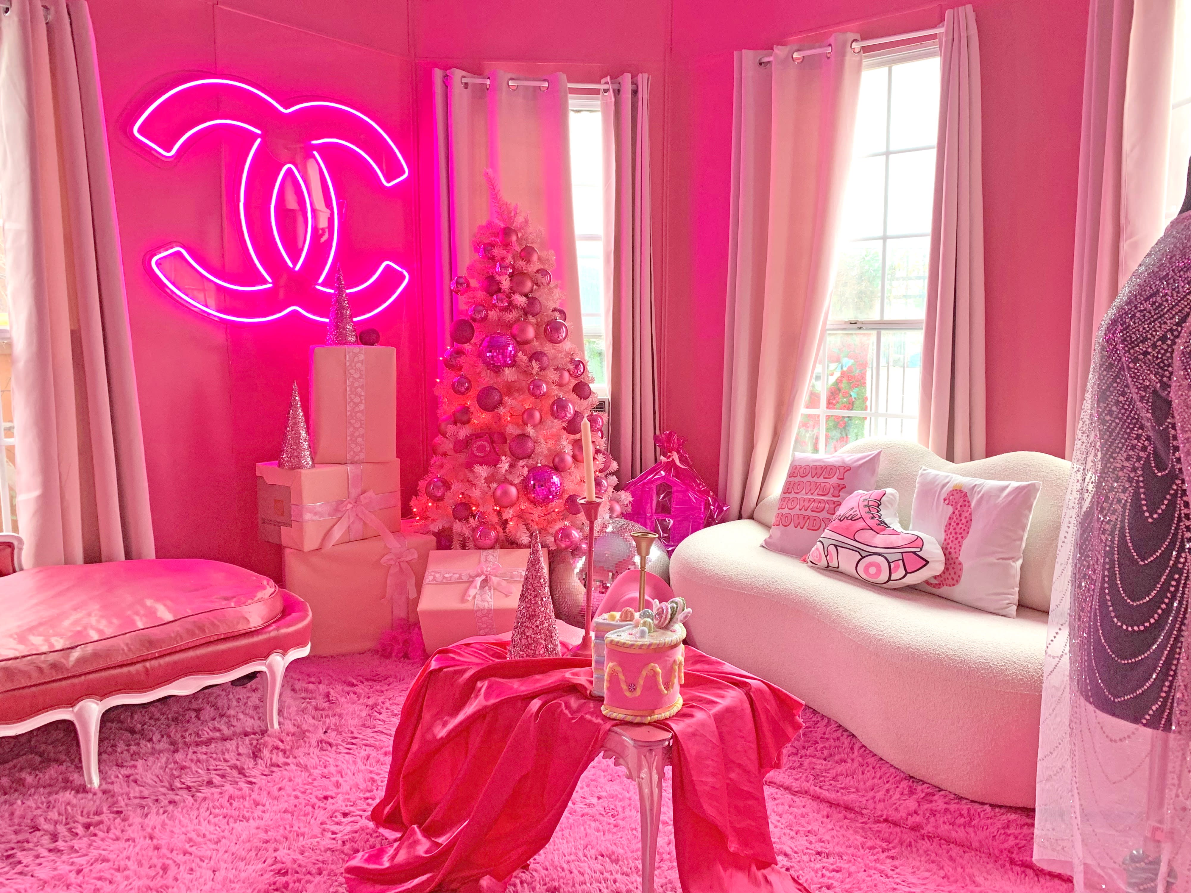A photoshoot takes place in a kitchen featuring a pink countertop, vintage appliances, and a black-and-white checkered floor.