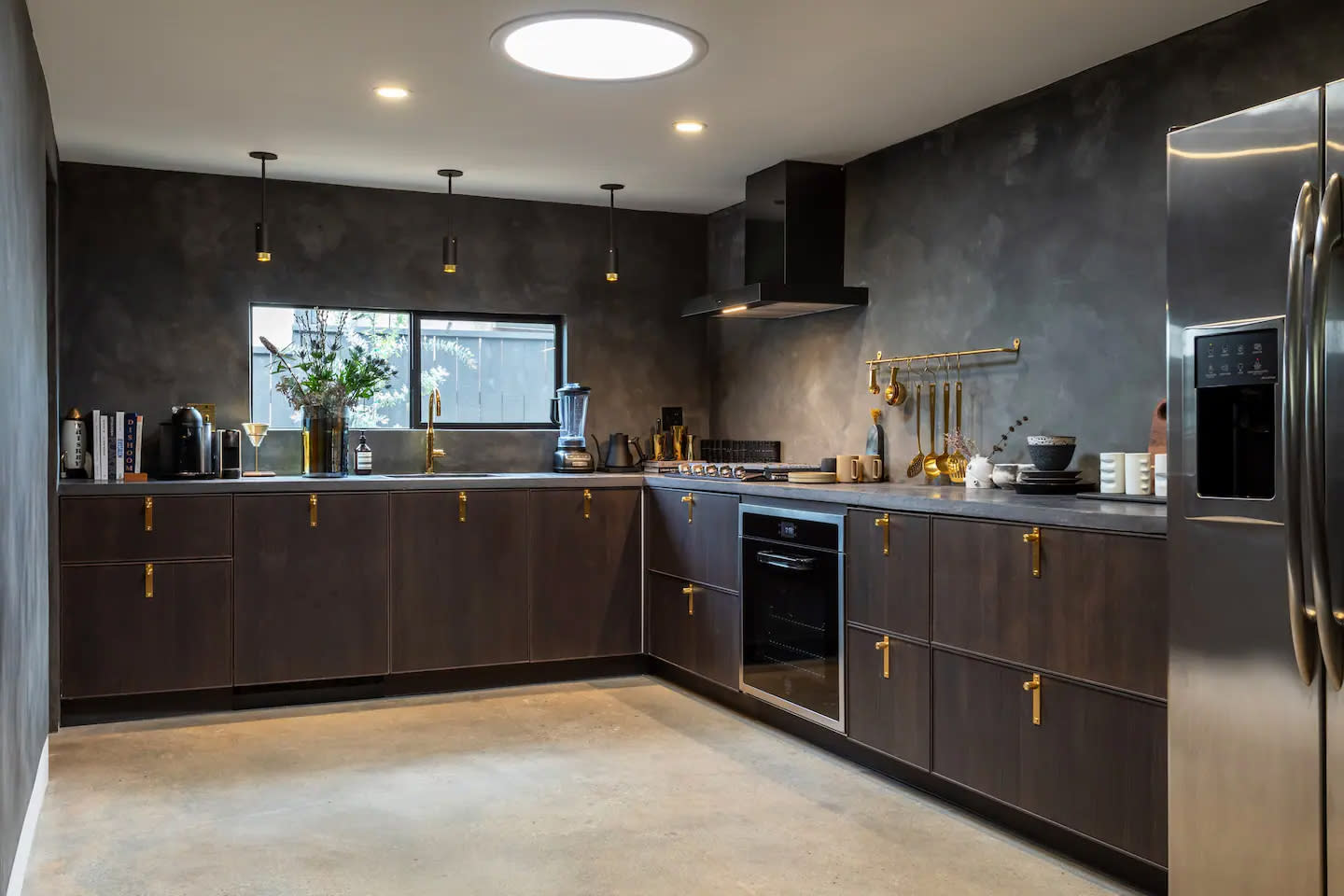 A grand piano is positioned in a modern room with large windows, accompanied by minimalist furniture and art pieces.