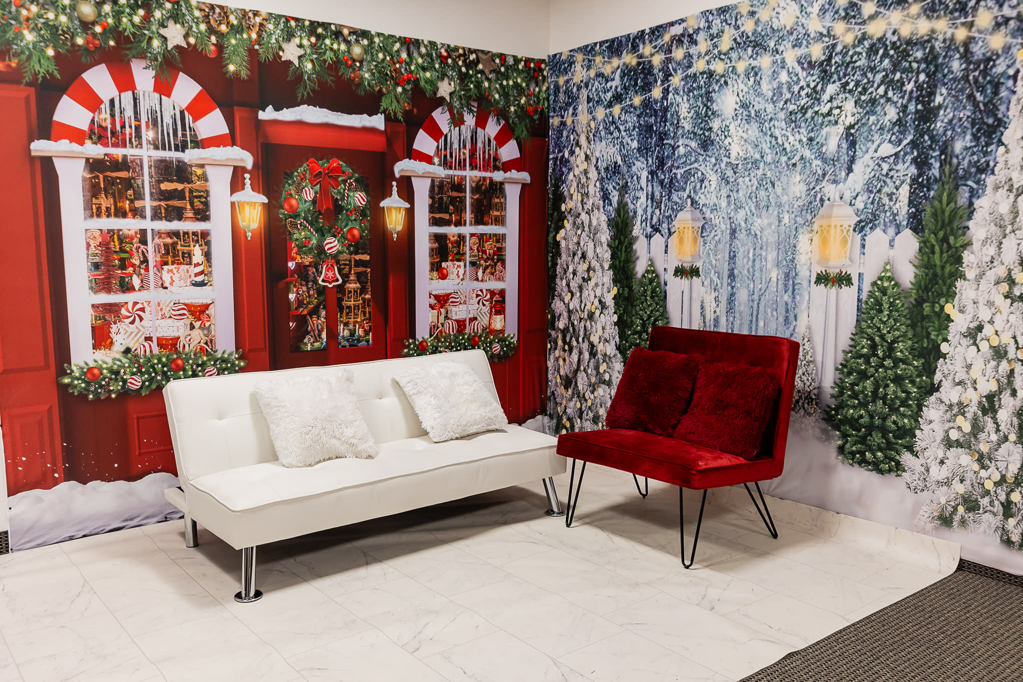 A man in a Santa Claus costume lies casually on a white couch in a festive holiday setting.