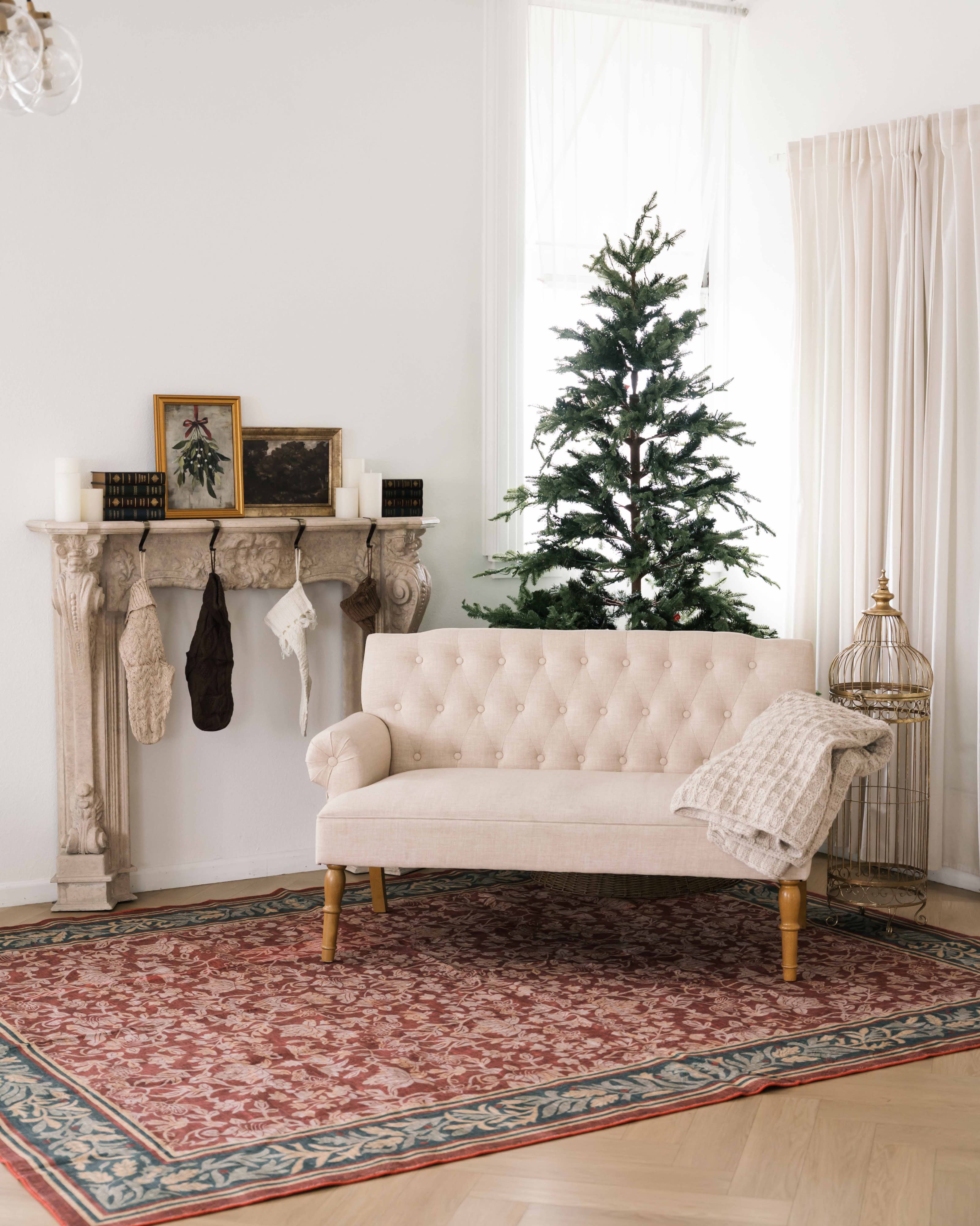 A child sits on a rocking horse next to a decorated Christmas tree.