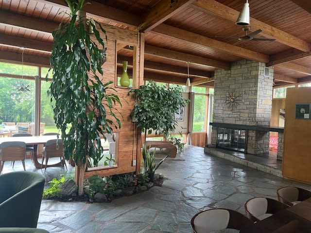 A beautifully arranged fireplace adorned with candles and rose petals creates a romantic setting for a marriage proposal.