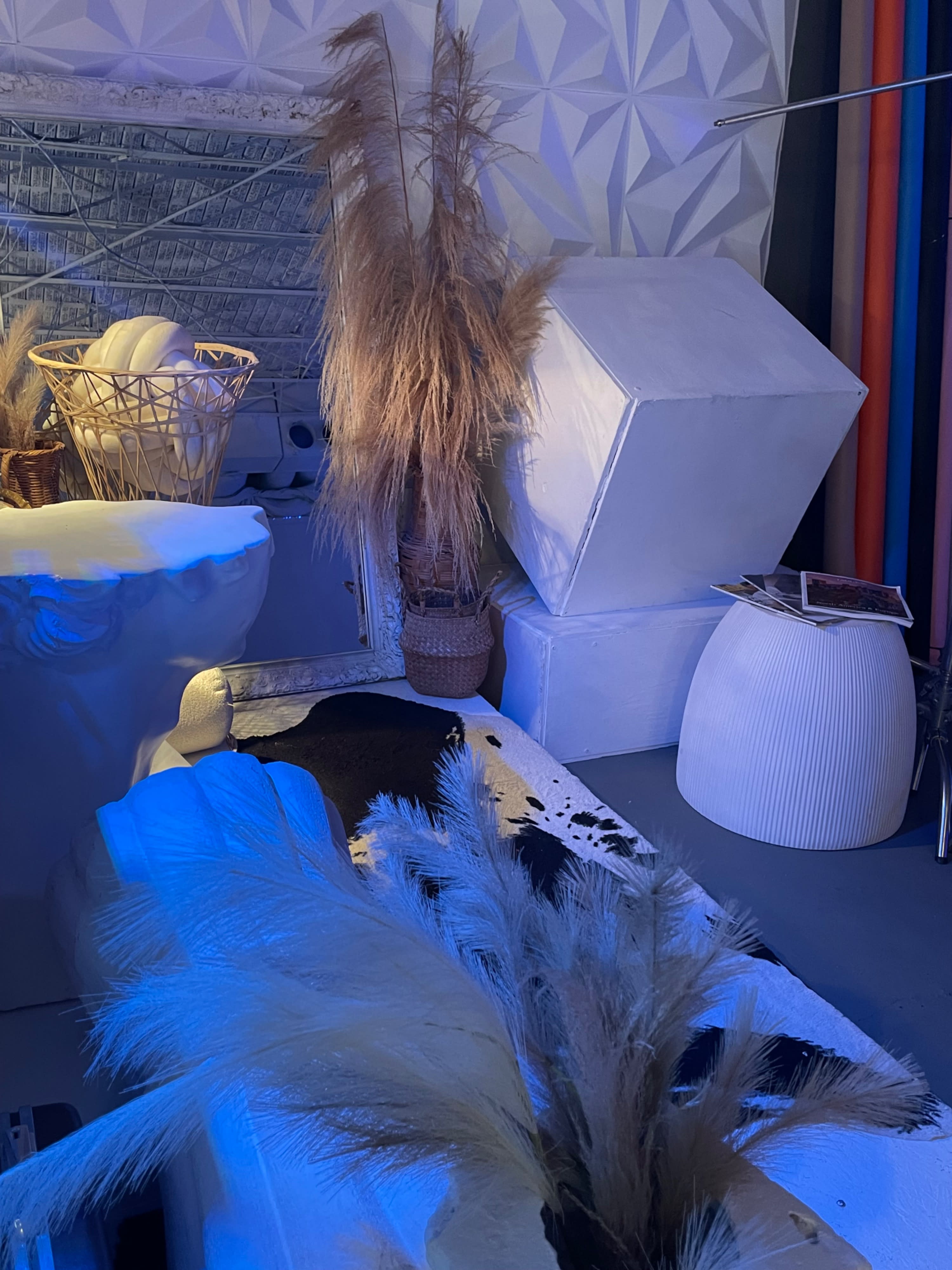 A model poses on all fours in a studio setting, showcasing a fashion outfit and accessories.