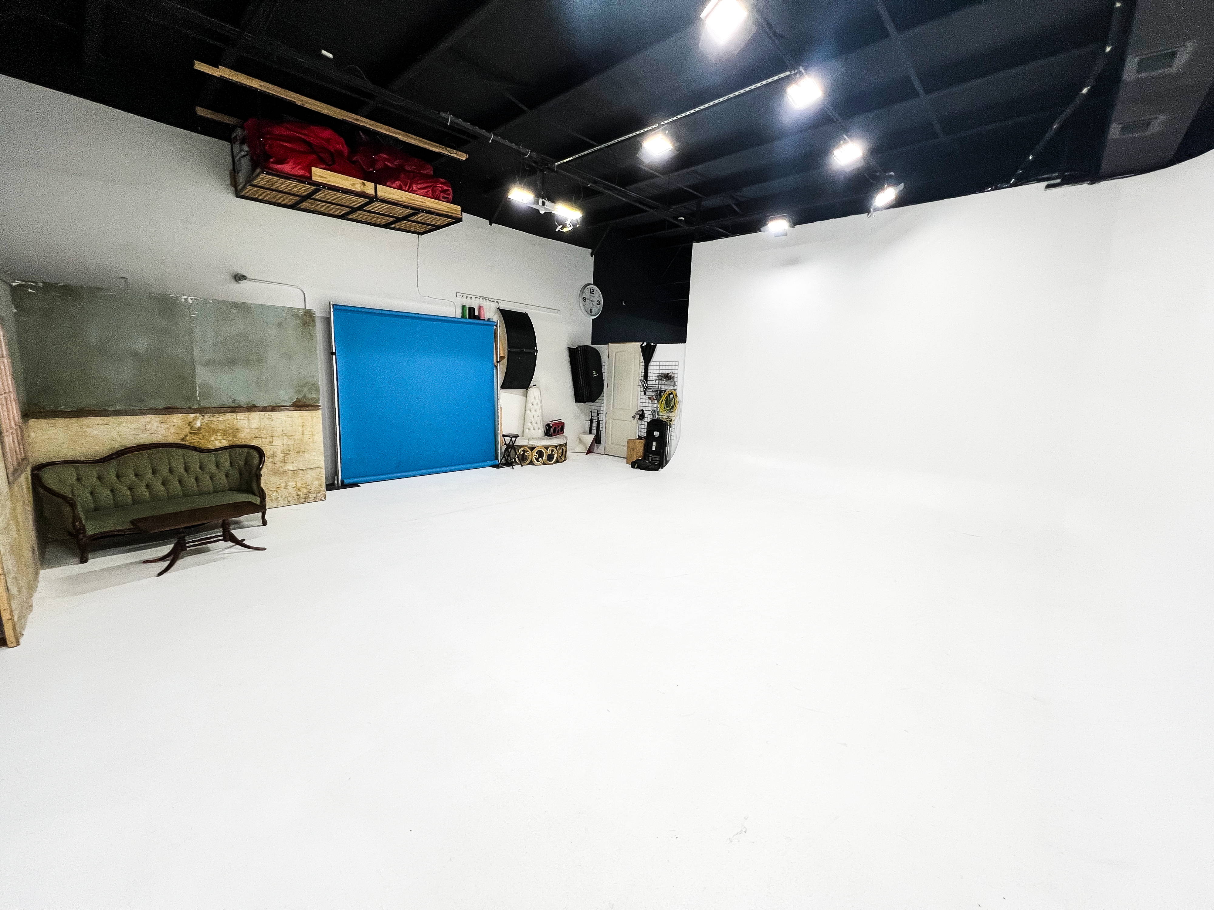 A director gestures towards a group of musicians being filmed in a blue-lit studio setting.