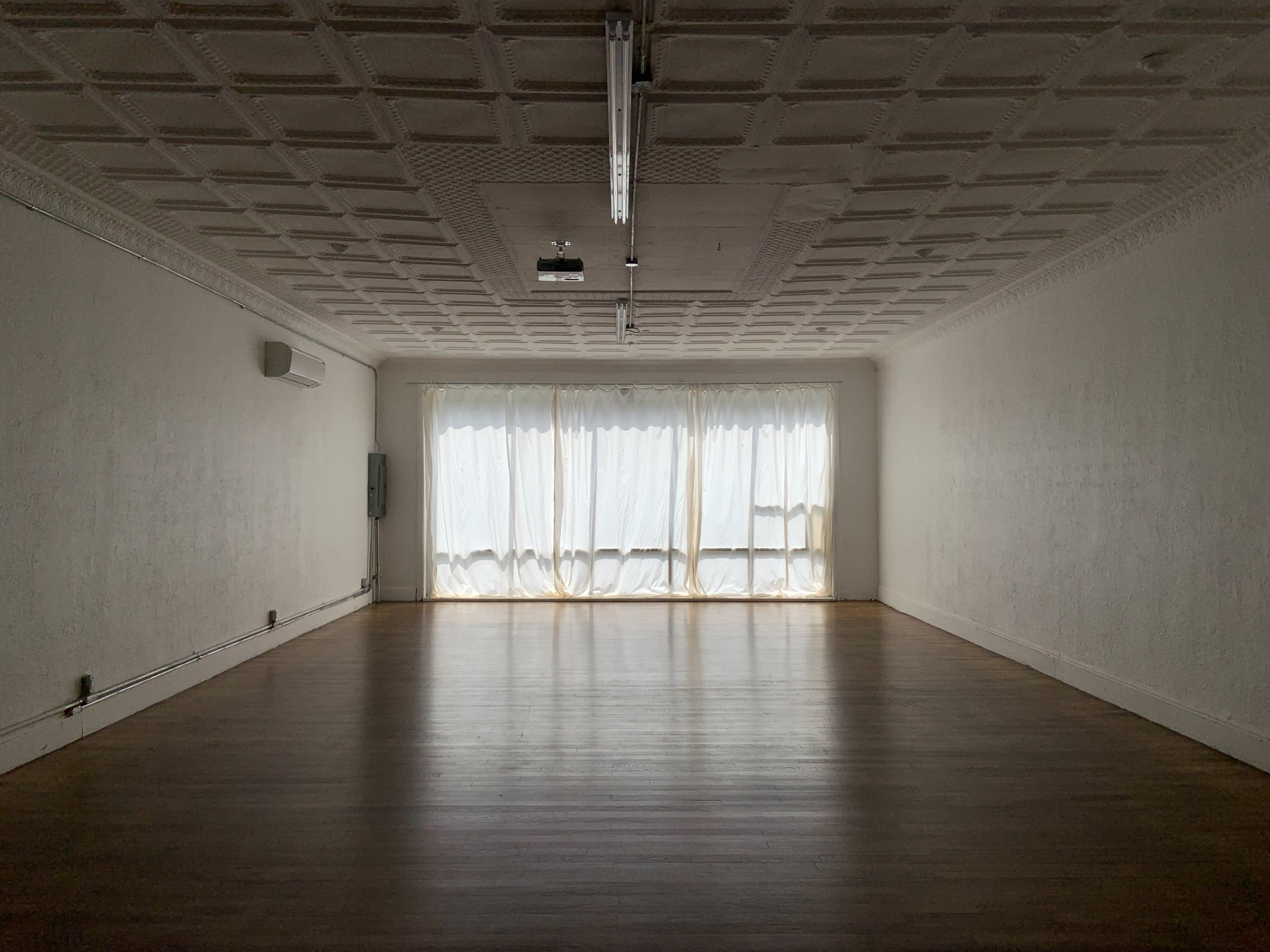 A string quartet performs in a well-lit room with large windows and draped curtains.